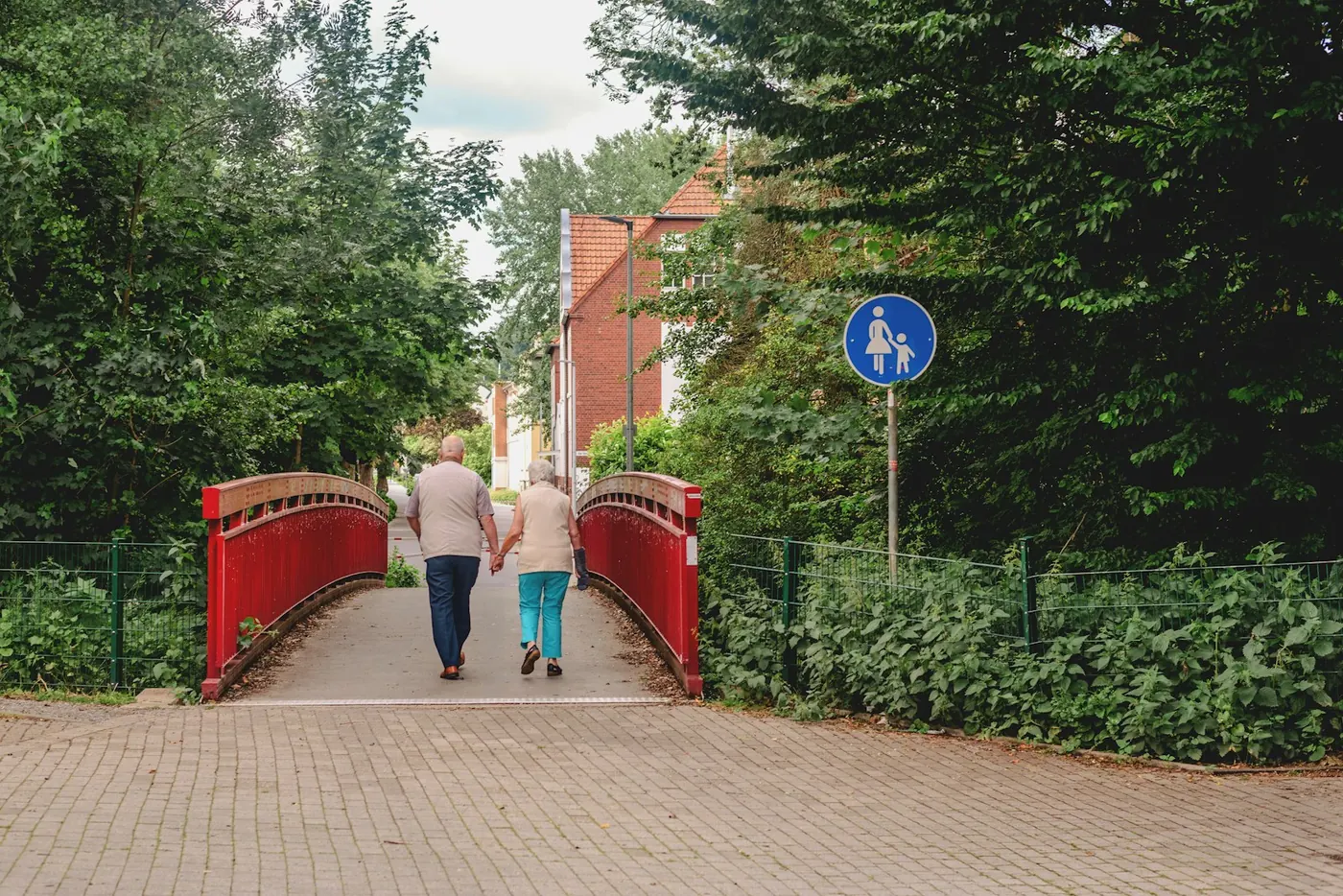 Two people walking across a bridge